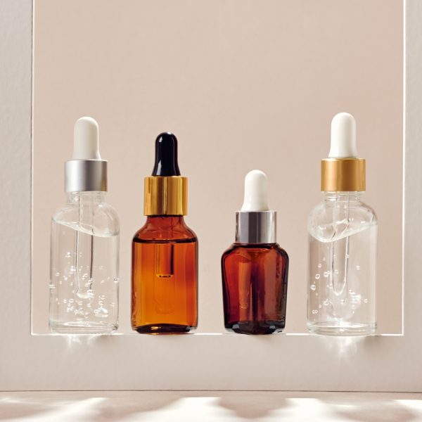 Anti-age cosmetic. Skincare collagen serum bottles. Neutral backgrounds and hard shadows.